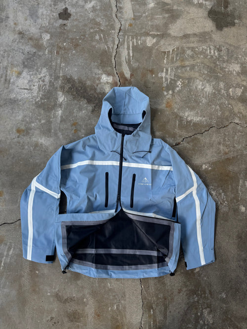 Blue raincoat with white accents on a textured concrete surface