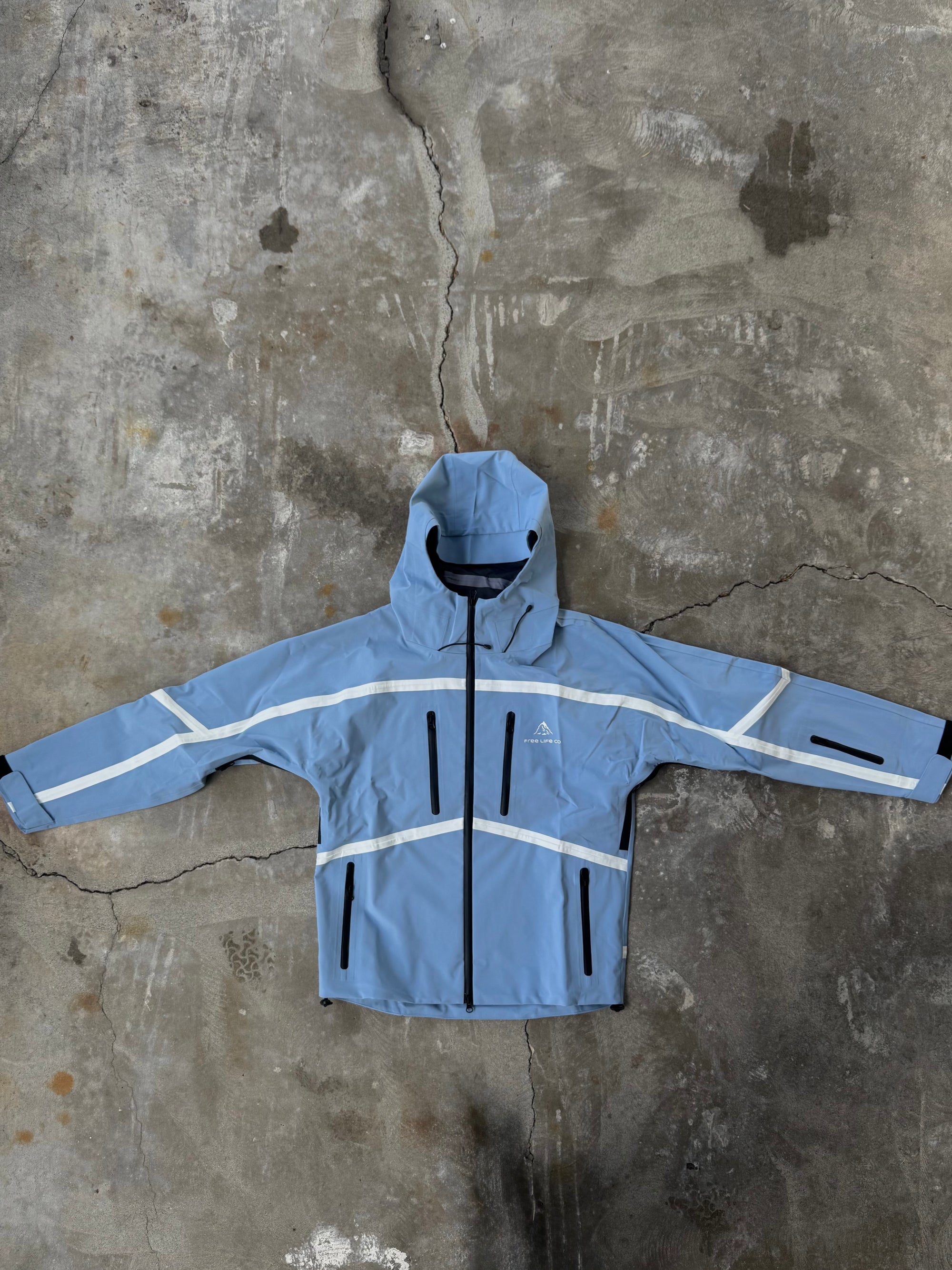 Blue jacket with reflective stripes on a textured concrete surface