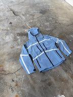 Blue jacket with white reflective stripes on a concrete floor