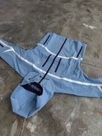 Blue raincoat with white reflective stripes on a concrete floor
